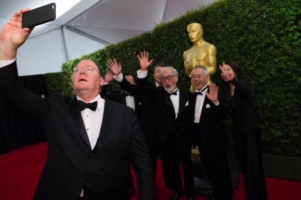 John Lasseter (left) takes a selfie with Honorary Oscar recipient Hayao Miyazaki (center), Toshio Suzuki and guests at the Governor’s Awards in 2014. [Photo: Academy of Motion Pictures]